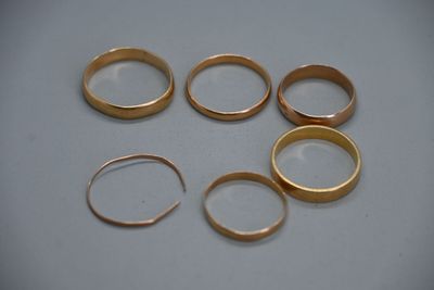 Plusieurs bagues en or sont disposées en cercle sur une table