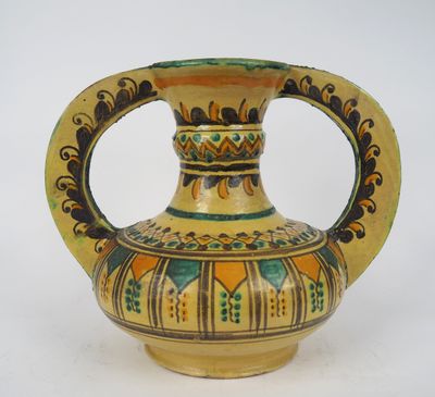 un vase jaune orné d'un motif vert et jaune