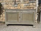 an image of a wooden cabinet sitting in front of a stone wall