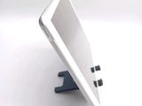 a tablet computer sitting on a stand on a white surface
