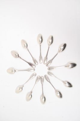 plusieurs cuillères et cuillères à soupe disposées en cercle sur une surface blanche