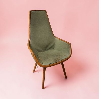 une image représentant une chaise verte sur fond rose