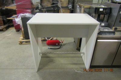 une petite table blanche sur laquelle se trouve un sac rouge