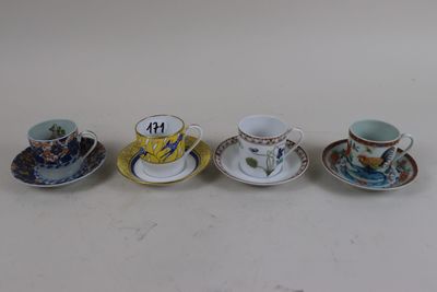 four cups and saucers are lined up on a white surface