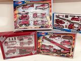 Trois camions de pompiers miniatures dans leur boîte et un camion de pompiers sont posés sur une table