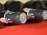 several bottles of wine are lined up on a red table