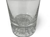 a clear glass with a small amount of water in it