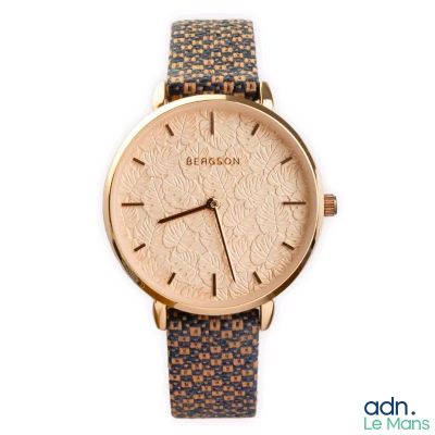 the watch is made of gold and brown leather with a floral pattern