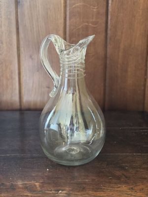 un pichet en verre transparent posé sur une table en bois