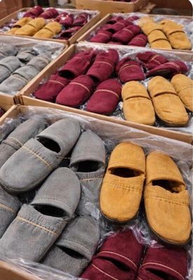 several pairs of slippers are in boxes on display in a store