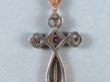 an image of a silver cross with a pink stone in the center
