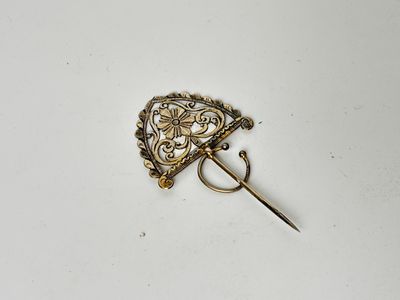a close up of a gold pin with a flower design on it