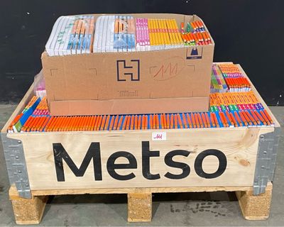 une boîte de stylos posée sur une palette, avec une étiquette portant l'inscription « Metso »