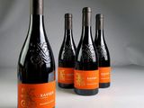 four bottles of wine are lined up on a white surface