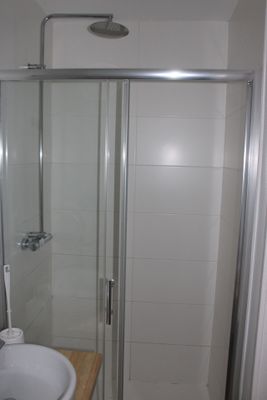 a small bathroom with a glass shower door next to a sink