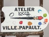 une pancarte sur laquelle on peut lire « atelier loopt ville parailt », posée sur une chaise en bois