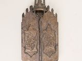 a metal plaque on the wall that has a cross on it