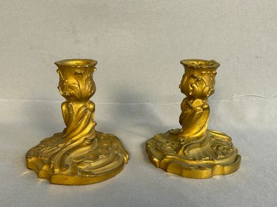 two gold candlesticks sitting on a table