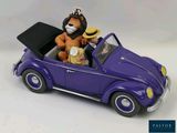 toy figurine of a lion and a lioness in a purple car