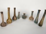 Plusieurs vases sont disposés en rangée sur une surface blanche