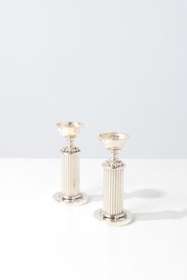 a pair of silver candlesticks sitting on top of a white table