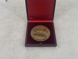 gold plated coin in a red box on a white surface