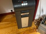 a paper shredder sitting on the floor next to a computer