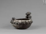 an image of a black pottery bowl with a boy sitting on it