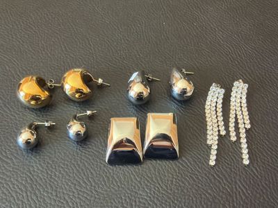 a lot of silver and gold jewelry on a black surface