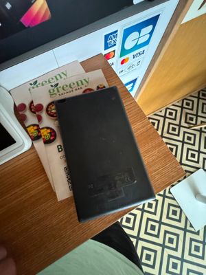 une personne assise à une table avec un téléphone portable et un livre