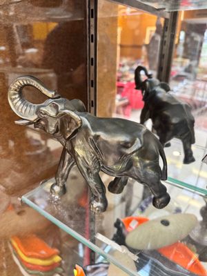 a glass display case filled with various figurines of elephants