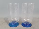 une paire de verres bleus et transparents posés sur une surface blanche