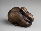 an image of a bronze sculpture of a rabbit on a white surface