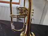 trumpet sitting on a table in a room next to a window