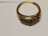 a close up of a gold ring with blue stones on it