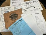 de nombreux papiers posés sur une table, avec un menu et une calculatrice