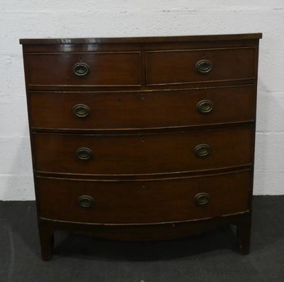 une commode en bois dans une pièce aux murs de briques blanches
