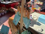 many umbrellas and brooms hanging on a pole