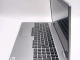 a silver laptop with a black keyboard on a white surface