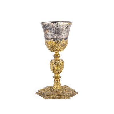 une coupe en argent et en or posée sur un socle, sur fond blanc