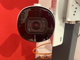 a camera that is sitting on a stand in front of a red wall