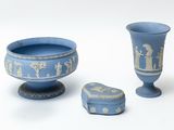 a blue vase and a small blue box on a white surface