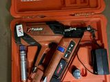 une boîte à outils orange contenant une agrafeuse, une agrafeuse et d’autres outils
