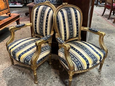 paire de chaises anciennes ornées de dorures et dotées de coussins rembourrés à rayures bleues et blanches