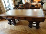 une grande table en bois au milieu d'un salon