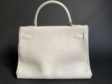 a white leather handbag on a black background