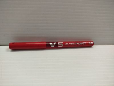 un stylo rouge posé sur une boîte blanche