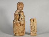une petite statue représentant une femme tenant un enfant dans ses bras et un homme tenant un bébé