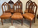four chairs with brown leather upholstered seats in a room