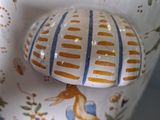 a white vase with a blue and yellow design on it
